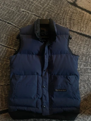 Canada goose  - En riktigt fin äldre canada goose väst som självklart är äkta! Storleken är xs och sitter dunder på dig mellan 170-185! Vi säljer den för 650kr. Ej hugget i sten men inga skambud! 9/10 använd ett par gånger och har haft den över 5 år och 4,5 år i garderoben