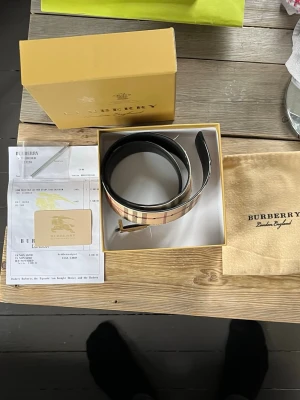 Burberry klassiskt rutigt bälte - Säljer detta burberry skärp, då det är för litet nu. Det är äkta allt på bilderna följs med. Skärpet är 80cm lång. Hör av er om ni har frågor!
