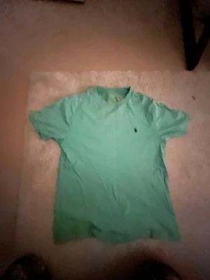 Grön t-shirt från Polo Ralph Lauren - Snygg grön t-shirt från Polo Ralph Lauren med klassisk passform och liten broderad logga på bröstet. Tillverkad i mjuk bomull och har korta ärmar. Perfekt till jeans eller shorts för en enkel och clean look.