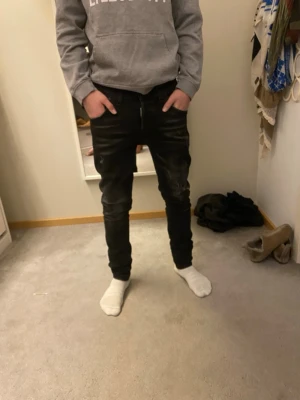 Svarta jeans från Dsquared2 - Säljer ett par svarta jeans från Dsquared2 med slitningar och lätt tvättade detaljer. Jeansen har klassisk femficksmodell och logotyp på bakfickan. Snygg passform som sitter tight hela vägen ner. Perfekt till vardagen och passar till allt ting, Tveka inte på o höra av dig Noah👍