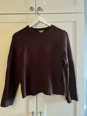 Mörkbrun stickad tröja Weekday - En stilren mörkbrun stickad tröja från Weekday med rund halsringning och långa ärmar. Tröjan har en rak passform och är tillverkad i ett mjukt, stickat material. Endast använd en gång. (nypris 400)