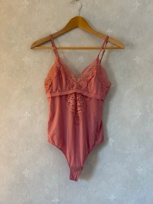 Rosa spetsbody med smala axelband - Snygg rosa body från intimissimi, slutsåld. mjukt tyg med stretch för skön passform. 