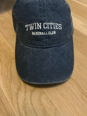 Mörkblå keps - Snygg mörkblå keps med böjd skärm och broderad text 'TWIN CITIES BASEBALL CLUB' i vitt framtill. Oanvänd!💕