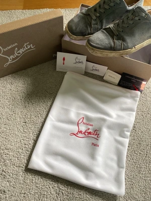 Blå sneakers från Christian Louboutin - Snygga blå sneakers från Christian Louboutin i mocka med klassisk låg siluett och vita sulor. Skorna har matchande blå skosnören och diskreta sömmar. Perfekta för dig som vill ha en exklusiv touch på din streetwear. Sick 5/10