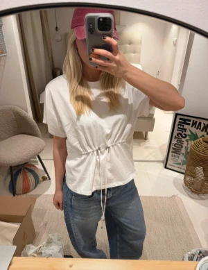 Vit t-shirt med snörning i midjan - Vit t-shirt med korta ärmar och snygg snörning i midjan!!!!! Oanvänd med prislapp kvar 👯‍♀️👯‍♀️👯‍♀️👯‍♀️🩷