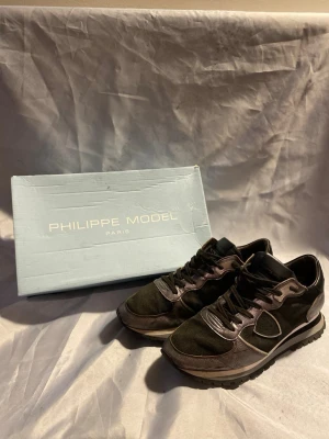 Philippe Model svarta sneakers - Stilrena svarta sneakers från Philippe Model med detaljer i mocka och läder. Skorna har en klassisk låg siluett, svarta skosnören och en bekväm sula med bra grepp. Perfekta för dig som gillar en clean och exklusiv look. Stl 41