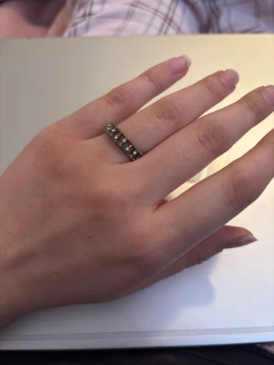 Silvrig ring - Silvrig ring med gems på vissa ställen. Anledningen t att jag säljer är pga att den är silver o jag är en guld tjej. Tyvärr så kommer jag inte ihåg vart jag köpt den ifrån.