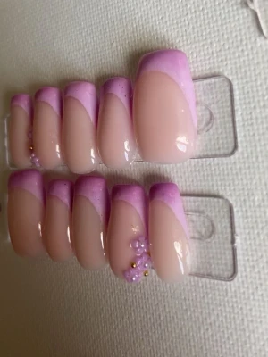 Press-on naglar med lila fransk tipp - Snygga press-on naglar i nude med lila fransk tipp och dekorativa små blommor med pärlor. Lila ombre.