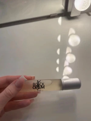 YSL Black Opium Eau de Parfum 20ml - YSL Black Opium Eau de Parfum i en smidig 20ml sprayflaska. Flaskan är cylinderformad i genomskinligt glas med svart text och ett silverfärgat lock. Perfekt att ha med i väskan för en lyxig doftboost när som helst.