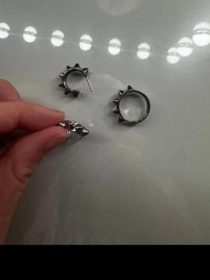 Silvrig ring & örhänge med nitar - Örhänge o ring sett från edblad. Märke är ingraverat i smyckena och ringen är i storlek S. fick i julklapp men använder ej 