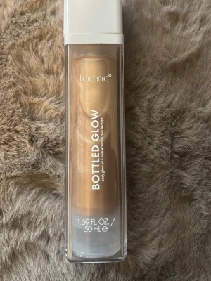 Technic Bottled Glow highlighter - Flytande highlighter från Technic i nyansen Bottled Glow. Kommer i en genomskinlig plastflaska med vit kork och innehåller 50 ml. Ger en skimrande, guldig glow till huden och är lätt att applicera för en strålande finish. Använd fåtal gånger