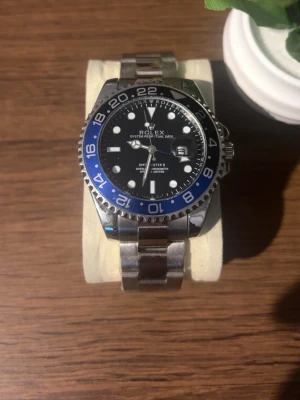 Klocka - Snygg klocka med svart urtavla och blå-svart vridring. Klockan har en robust länk i rostfritt stål och tydliga vita markeringar. Perfekt för dig som gillar klassisk och sportig stil. Ikonisk design och riktigt schyssta detaljer. Priset kan diskuteras!