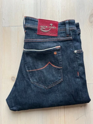 Jacob Cohën Jeans - Säljer nu dessa snygga Limited Edition Jacob Cohën jeans!  Den har färgen mörkblå, eftersom den är i raw denim.🔵  Storleken är 38, och jag skulle säga att den sitter som det också, alltså är den true-to-size. Passformen är 620, alltså sitter den som slim.  Dessa jeans är väldigt svåra att få tag i, eftersom det är bara 300 par som har tillverkats!   Skicket är 10/10, inte använd alls!  Nypriset är 9999kr❌ Mitt pris är 2499 kr✅  Om du har några frågor eller funderingar är det bara att fråga!