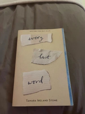 Every Last Word av Tamara Ireland Stone - En engelskspråkig pocketbok med beige omslag och handskriven text på rivna papperslappar. Romanen handlar om Samantha som kämpar med OCD och att hitta sig själv bland vänner och poesi. Perfekt för dig som gillar ungdomslitteratur och känslomässiga berättelser.