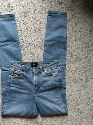 Ljusblå skinny jeans med fem fickor - Säljer ett par ljusblå skinny jeans med klassisk femficksdesign och dragkedjegylf. Jeansen har en snygg tvätt och smal passform som sitter tajt längs benen. Materialet är mjukt denim med stretch för extra komfort. Perfekta till en avslappnad och trendig look.