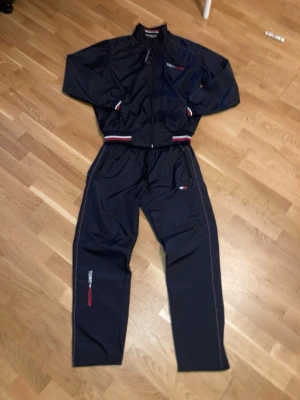 Mörkblått tracksuit set Tommy Hilfiger - Mörkblå tracksuit set från Tommy Hilfiger. Helt ny o oanvänd.