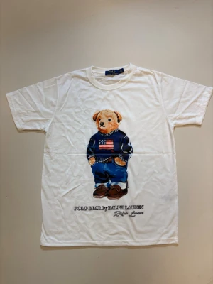 Vit Ralph Lauren T-shirt - Vit Ralph Lauren Polo bear T-shirt // mycket bra skick aldrig använda // storlek M // mått, längd 65cm Axelbredd 41cm // Skriv vid minsta fråga eller fundering🤝