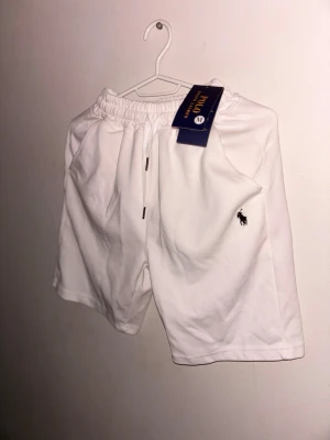 Polo Ralph Lauren shorts - vita shorts från Polo Ralph Lauren i helt nytt skick, knappt använda. Klassisk design med broderad logga på vänster ben. Perfekta för sommaren och tillverkade i mjuk bomull för maximal komfort. Skriv för fler bilder eller om ni har frågor!😄