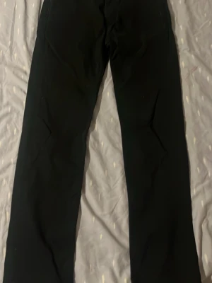 Svarta raka jeans - Säljer ett par svarta jeans med rak passform. Klassisk femficksmodell och stilren look som funkar till det mesta. Jeansen har normal midja och är tillverkade i ett mjukt denimtyg.