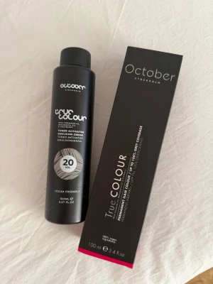 October True Colour hårfärg & aktivator - October True Colour permanent hårfärg och toner activator. Hårfärgen ger upp till 100% täckning av grått hår och kommer i en svart tub på 100 ml. Toner activatorn är vegansk och kommer i en svart flaska på 150 ml. Båda produkterna har stilren svart design.