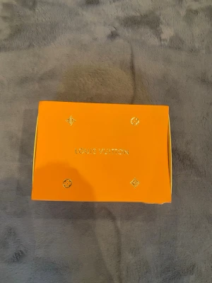 Louis Vuitton handväska med box - Exklusiv handväska från Louis Vuitton, levereras med original orange box och dustbag med logotyp. Perfekt för dig som vill ha en lyxig accessoar från ett av världens mest ikoniska modehus.