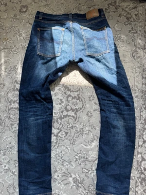 Blå Nudie Jeans/ LEAN DEAN - Stilrena jeans från Nudie jeans, modellen är Lean Dean vilket är en utav de mer populära modellerna inom nudie jeans. Storleken är 31/30. Priset är inte hugget i sten och kom gärna med frågor och funderingar/MVH EDDIE