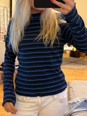 Blå och svart randig långärmad tröja - Mysig långärmad tröja med blå och svarta ränder. Tröjan har en klassisk rund halsringning och är i en mjuk, stretchig bomullsblandning. Det står att den är i L men skulle säga att den sitter som en S/M! 💙