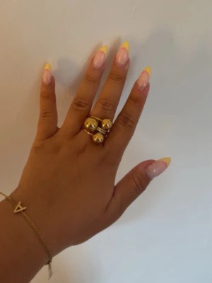 Guldfärgad statementring med kulor - Säljer en unik guldfärgad ring med tre stora, blanka kulor som dekoration. Ringen har en chunky design och är perfekt för dig som gillar att sticka ut med accessoarer. 
