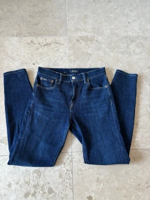 Polo Ralph Lauren jeans - Jeans Polo Ralph Lauren Skinny Fit 👖  Snygga Polo Ralph Lauren skinny fit-jeans i en klassisk mörkblå färg, tillverkade av bomull med stretch. 4st fickor fram och bak med logga på. Klassisk läder logga baktill på byxorna  ⭐️ Skick: 8/10  🎲 Storlek: 25R/150/160 🎨 Färg: Mörkblå  📦 Snabb och noggrann leverans.