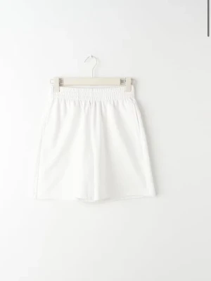 Vita loose shorts med resårmidja - Snygga vita shorts med loose passform och elastisk midja. Perfekta för varma sommardagar och enkla att matcha med olika toppar. Tillverkade i ett mjukt material som känns skönt mot huden.