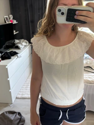 Kappahl  - Söt vit topp med bred volangkant runt axlarna och fina broderade detaljer. Kan bäras både på axlarna och offshoulder. Skulle säga att om man har xs i storlek kan man ha denna. Öppen att diskutera pris💕