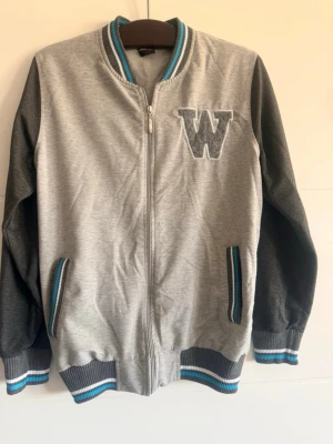 🩶✨ Herr hoodie/ziptröja i grå – Lacaton Sports Wear ✨🩶 - 🩶✨ Herr hoodie/ziptröja i grå – Lacaton Sports Wear ✨🩶  🧥 Säljer en grå herr-hoodie med dragkedja, med broderad bokstav “W” framtill och fickor. Bekväm och sportig stil. I mycket bra skick, perfekt för vardagsbruk 💕  🏷️ Märke: Lacaton Sports Wear 👕 Storlek: L  📏 Mått: 📐 Bredd: 100 cm 📏 Längd: 66 cm  💌 Hör gärna av dig om du har frågor. Välkommen att köpa! 😊 