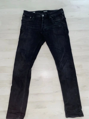 Svarta jeans Slim/Glenn jack&jones - Slim jeans från jack and jones, modellen är glenn och storleken W28 L32. Fint skick och har mycket kvar att ge