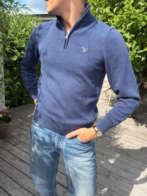 Stickad halfzip  från Gant - Snygg marinblå stickad tröja från Gant med halv dragkedja och hög krage. Perfekt till jeans för en clean och klassisk look.