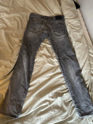 Gråa replay jeans - Säljer ett par gråa jeans från Replay med klassisk femficksdesign och slim fit. Jeansen har slim passform och är tillverkade i mjukt bomullsmaterial med lite stretch för extra komfort. Perfekta till vardags och enkla att matcha. Tveka inte att höra av er