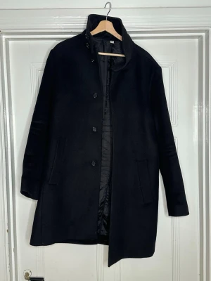 Tiger of Sweden Kashmere Rock - Stilren svart rock i cashmere med knäppning framtill. Rocken har två snedställda fickor och är för extra komfort. Passar perfekt till höst och vinter och har en tidlös design som funkar till många stilar. Har endast använts sen i December, bulken tog mig för hårt🥲, Storlek 50. Skriv direkt vid frågor! Priset är naturligtvis diskuterbart.🌟