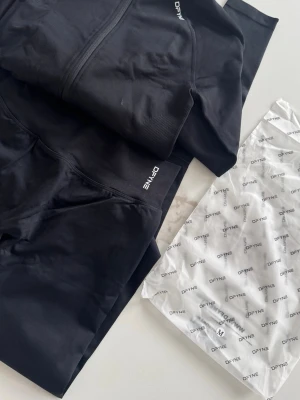 Svarta leggings från DFYNE - Snygga svarta leggings från DFYNE med hög midja och tight passform. Tillverkade i ett stretchigt och mjukt material som sitter skönt på kroppen. Perfekta för träning eller chill. Diskret logga vid midjan och klassisk design som passar till allt.