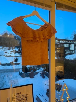 Rosa offshoulder topp med volang - Trendig rosa offshoulder topp med bred volang runt axlarna. Tillverkad i ett strukturerat, stretchigt tyg som ger en snygg passform. Perfekt för dig som vill sticka ut med en feminin och modern look, vet inte storleken då lappen är borta men tror den är ifrån Lindex och passar mig som brukar ha 164(s/zs)