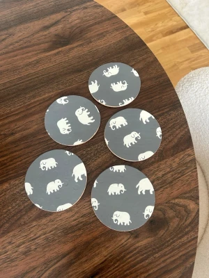 Svenskt tenn glasunderlägg - Fem runda glasunderlägg i kork med svensk tenn tapet. De är lackade. 