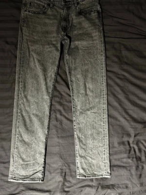 Levis 502, tapered fit - Ett par gråa Levis byxor, modell 502. Passformen är rak och är i storlek 33/32. Fler bilder kan fixas !