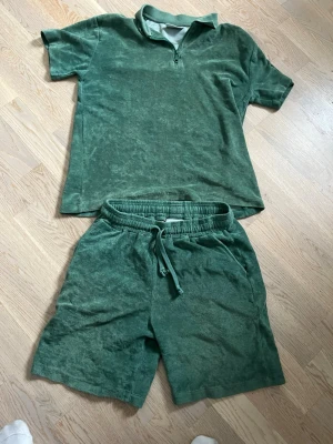 Gröna frottéshorts från Grunt - Gröna shorts från Grunt i mjuk frotté med dragsko i midjan och avslappnad passform. Perfekta för sommardagar och chill häng. Matcha med t-shirt för en komplett look.