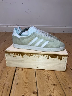 Adidas Gazelle - Säljer ett par Gazelles då jag inte använder de längre. Skorna är använda men som inte syns så tydligt på skorna. Det främsta är tån på vänstra skon som är lite miss färgad som syns på bild. Annars är skorna jätte fina och har mycket kvar att ge.😃  Märke: Adidas  Model: Gazelle  Storlek📏: 43,1/3 eller 27,5-28 cm Skick: 7/10 Då skorna är använda  🎨: Beige  🚚: Skickas inom 1-2 dagar😁  Har tyvärr tappat bort boxen till skorna  Priset är inte hugget så kom gärna med förslag 🤩