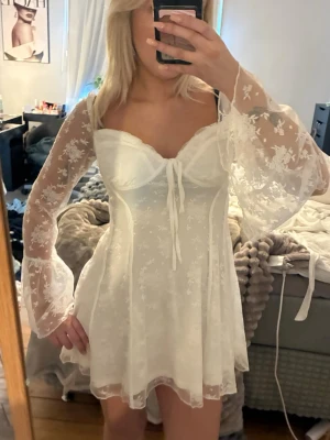 Vit spetsklänning med vida ärmar  - En vit klänning perfekt nu till studenttiderna, spets och vida ärmar, aldrig använd utan bara provad, prislappen kvar 