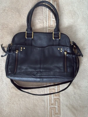 Svart handväska med gulddetaljer -  Köptes i New York, men har inte varit använd på ett tag