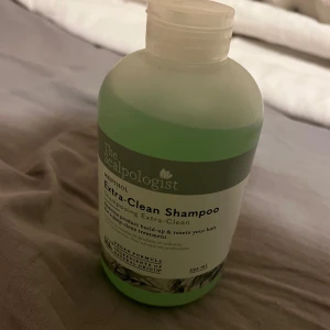 The Scalpologist Extra-Clean Shampoo - Fräsch grön schampoflaska från The Scalpologist med mentol. Schampot är veganskt och designat för att djuprengöra hårbotten och ta bort produktrester. Flaskan har en praktisk tryckkork och rymmer 300 ml.