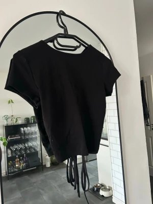 Svart t-shirt med knytning i ryggen - Väldigt fin svart t-shirt med öppen rygg o knytning i ryggen. 💕