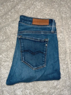 Replay jeans  - Snygga blåa jeans ifrån Replay. Jeansen sitter skönt och har en tajt passform. Midja 35cm, längd 104cm. JAG SKICKAR EJ FLER BILDER NÄR JAG BÄR JEANSEN! för bättre inblick i passformen rekommenderar jag att googla på modellnamnet. För storleksguide kolla måtten noggrant då jeansen alltid kan vara uppsydda heller krympta och jag ej tar emot returer :) s6,5