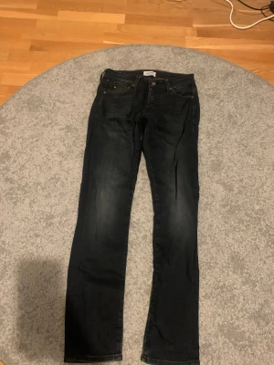 Svarta jack & jones jeans - Säljer ett par svarta jeans med rak passform och klassisk femficksdesign. Jeansen har subtila slitningar och är tillverkade i ett stretchigt denimtyg för extra komfort. Perfekta till en avslappnad stil och passar till det mesta.