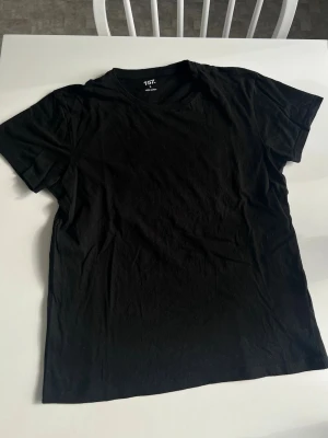 Svart basic t-shirt, storlek S - En svart t-shirt till herr. Sparsamt använd. Modell ”MARLON”.