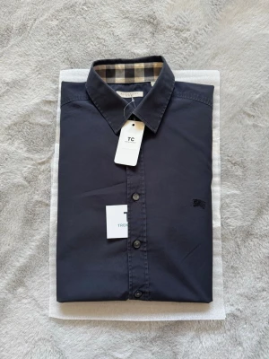 Burberry skjorta - Super fin svart burberry skjorta i storlek L, skjortan är i mycket fint skick utan några defekter. Burberry mönstret finns på båda ärmsluten och även runt om kargens indsida. Nypris 5000kr mitt pris endast 1200kr. Hör av er vid frågor. Mvh Trend closet🙌